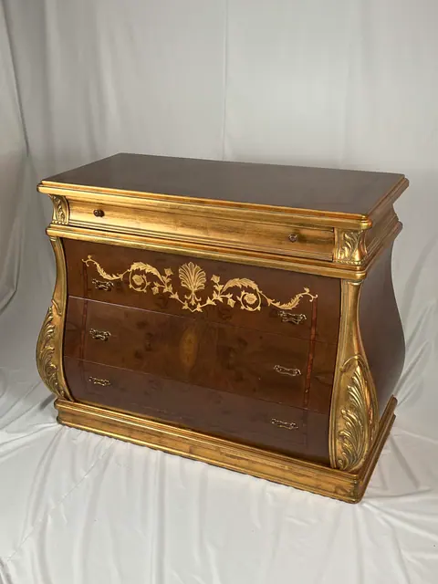 Bombé chest with three drawers between gilded corner columns.