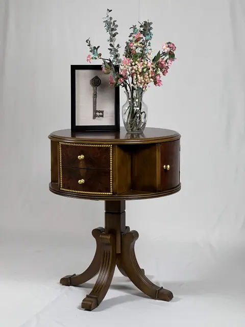 Drum table with two drawers, on a pedestal with splayed legs.