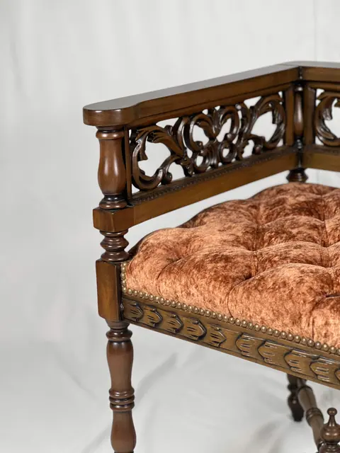 Close view of the buttoned seat where it meets the carved seat rail.