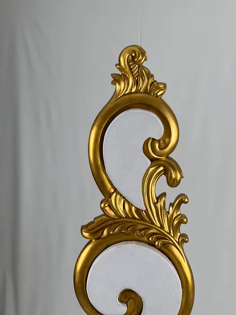 The back panel, carved as scrolls and leaves around an open centre.