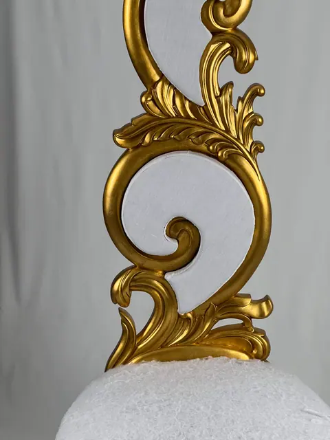 Close view of the crest, where the carving turns into a leaf spray.