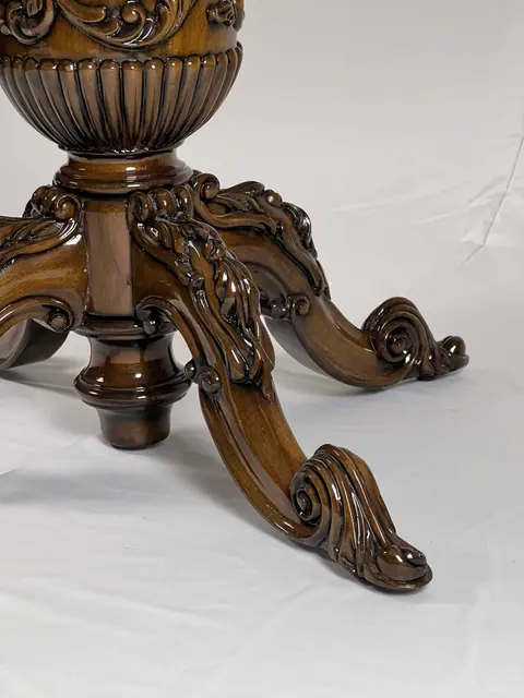 Close view of the carved pedestal and the scrolled legs.