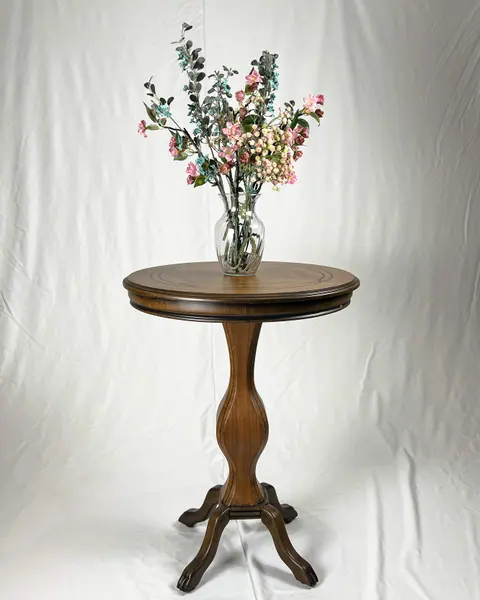 The table with a glass vase of flowers on it.