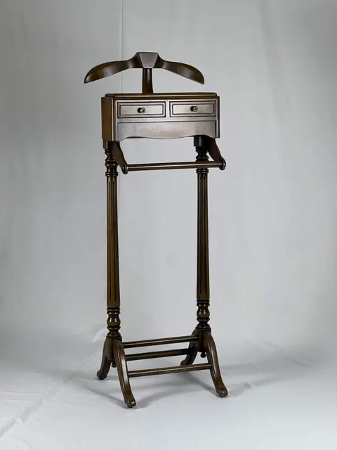 Wooden valet stand with a shoulder rail and a small drawer.