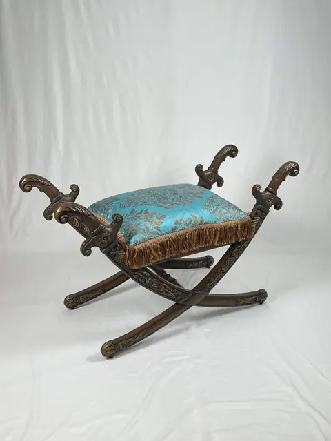 X-frame stool with a teal silk cushion and bullion fringe.